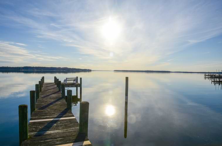 Sun shining over a lake and pier in Leonardtown Maryland