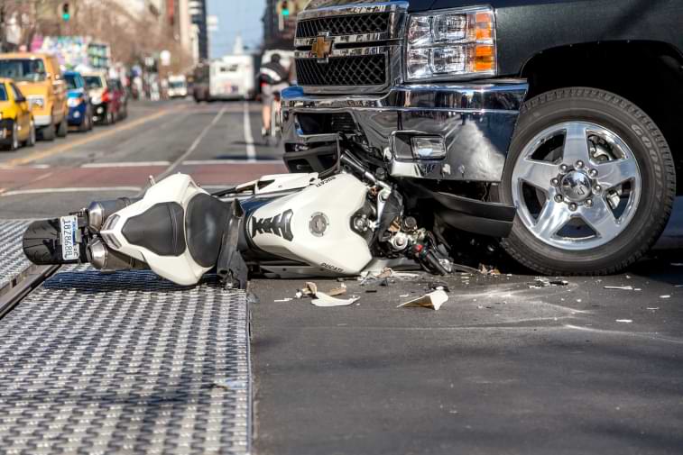 Motorcycle laying in street crushed after car and motorcycle accident 
